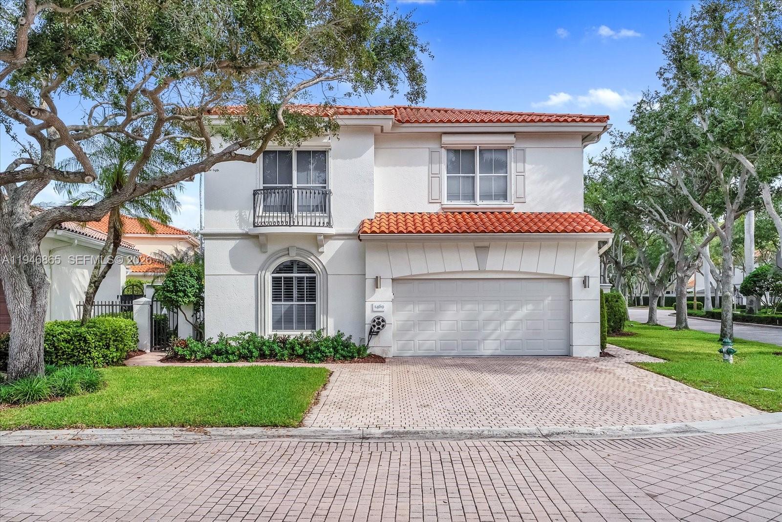 1469 Shoreline Way Hollywood, FL 33019 - Photo 4 of 46 a front view of a house with a garden and trees