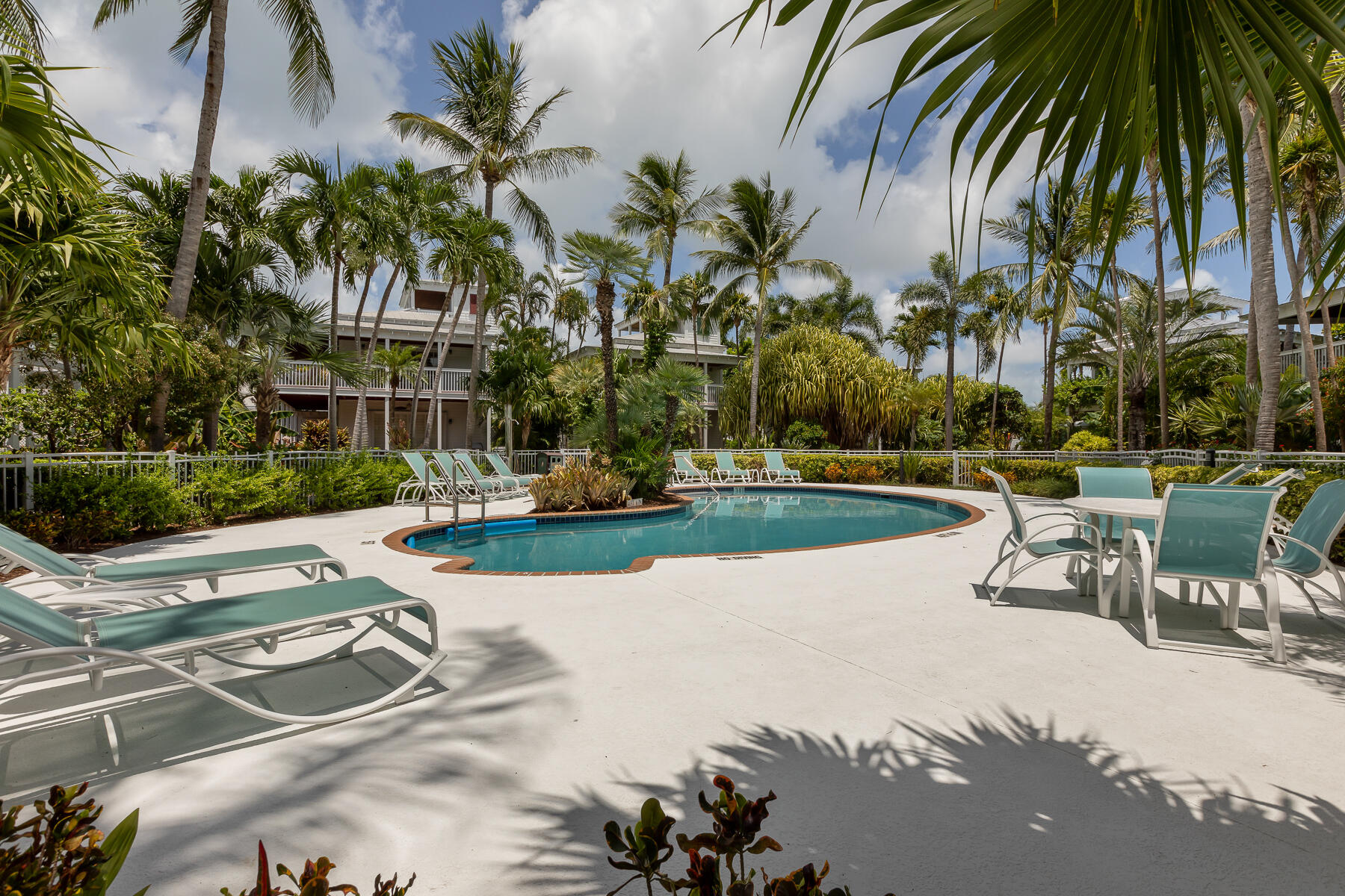 63 Sunset Key Drive Key West, FL 33040 - Photo 33 of 47 a view of a swimming pool with a table and chairs