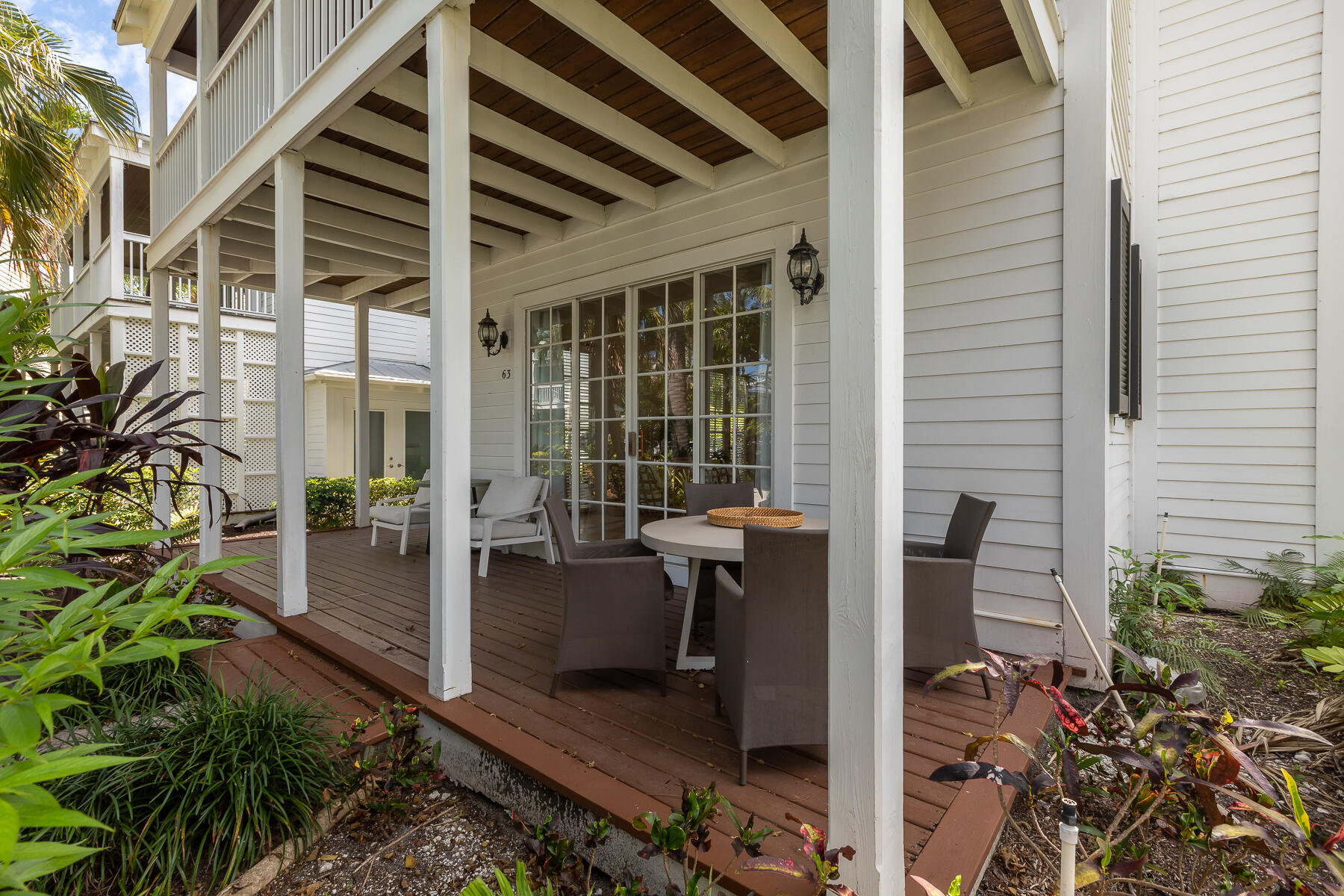 63 Sunset Key Drive Key West, FL 33040 - Photo 6 of 47 a balcony with table and chairs and potted plants