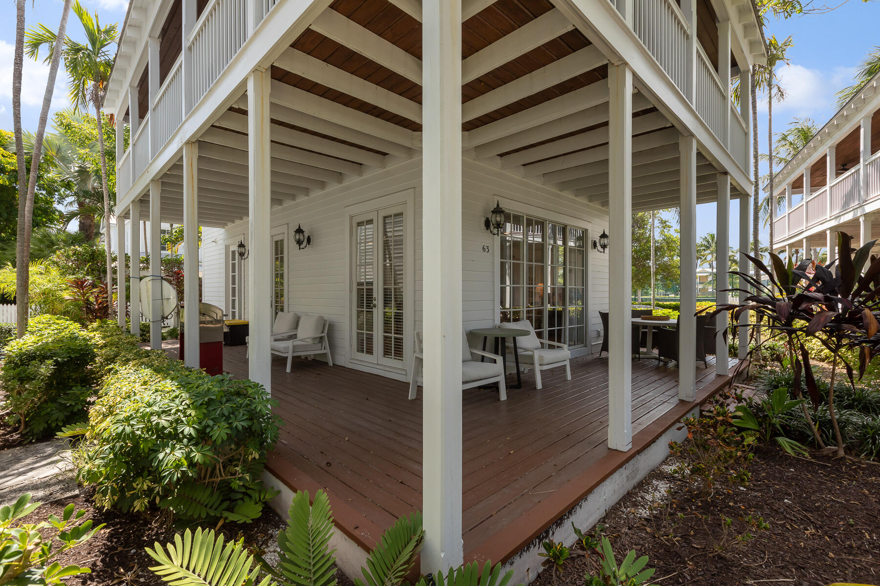 63 Sunset Key Drive Key West, FL 33040 - Photo 8 of 47 a view of a patio with table and chairs potted plants and large tree