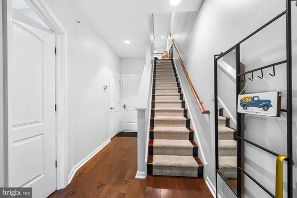 a view of staircase with lots of frames on wall and a window