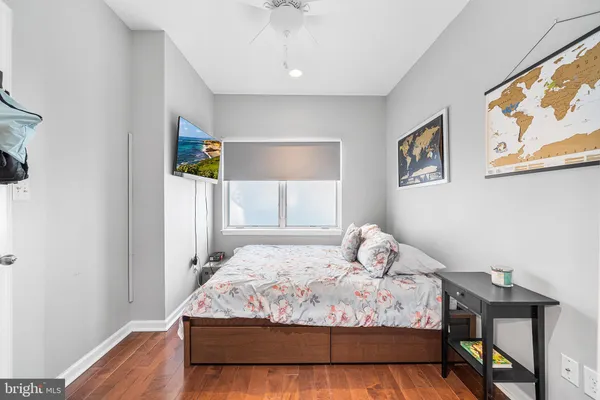 a bedroom with a bed and painting on the wall