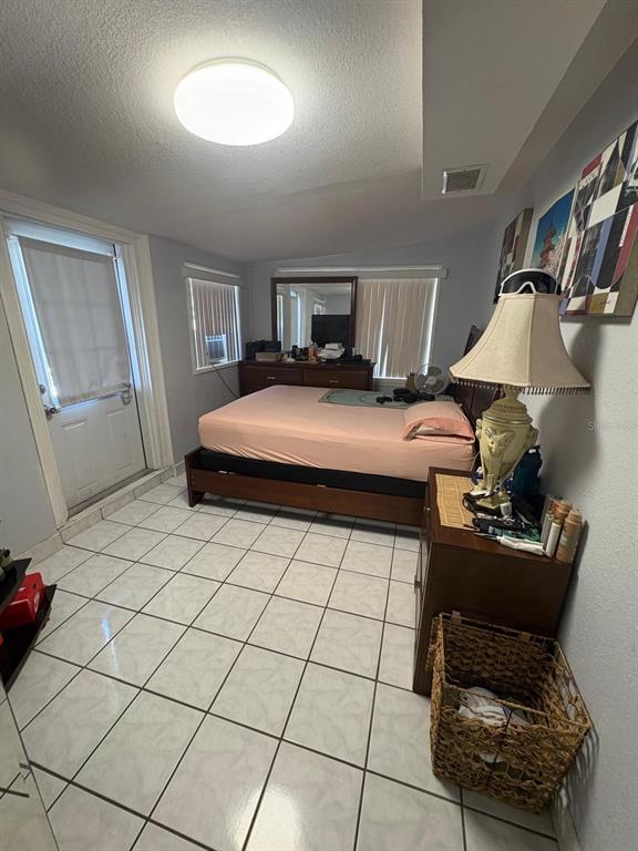 6005 West Clifton Street Tampa, FL 33634 - Photo 19 of 32 a bedroom with a bed and a stool