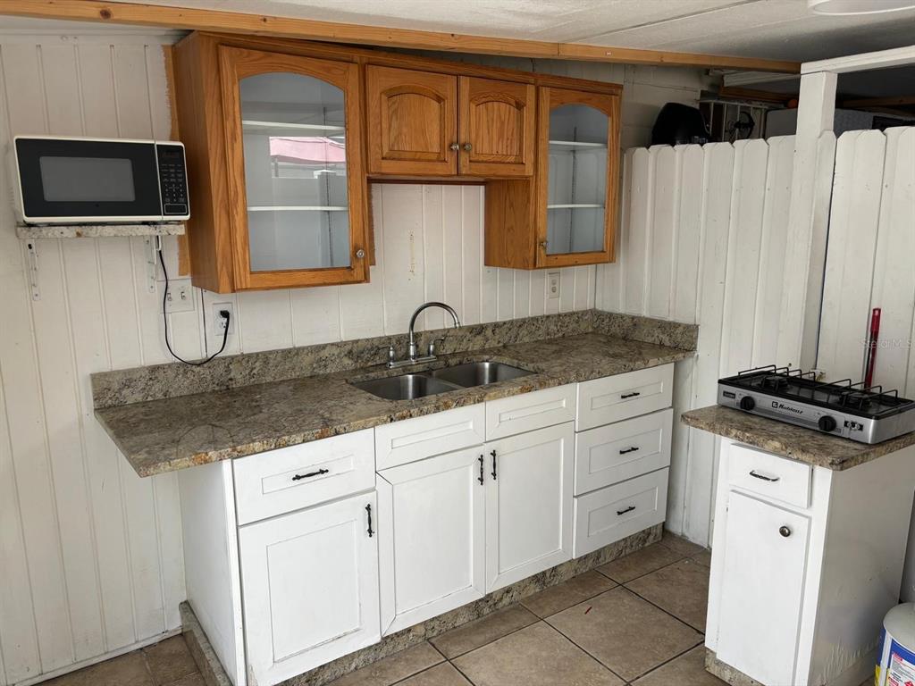 6005 West Clifton Street Tampa, FL 33634 - Photo 28 of 32 a kitchen with granite countertop a sink stove and cabinets