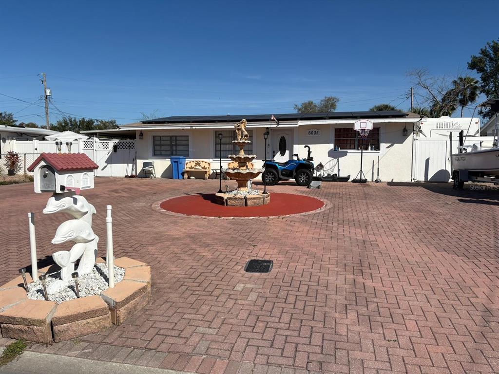 6005 West Clifton Street Tampa, FL 33634 - Photo 3 of 32 a view of a patio with table and chairs potted plants with a flat tv screen