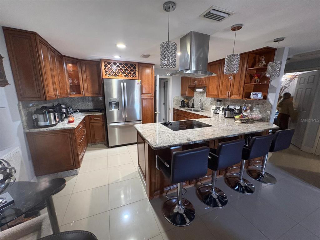6005 West Clifton Street Tampa, FL 33634 - Photo 4 of 32 a kitchen with sink refrigerator and chairs