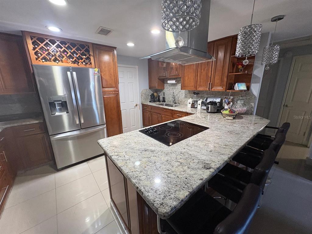 6005 West Clifton Street Tampa, FL 33634 - Photo 7 of 32 a kitchen with granite countertop a refrigerator a stove and a sink