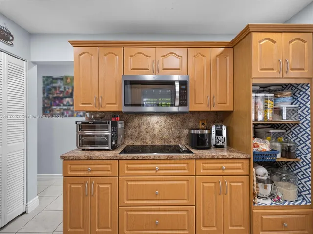 a kitchen with stainless steel appliances granite countertop a stove microwave and cabinets