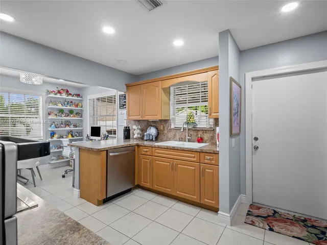 a kitchen with granite countertop cabinets and window
