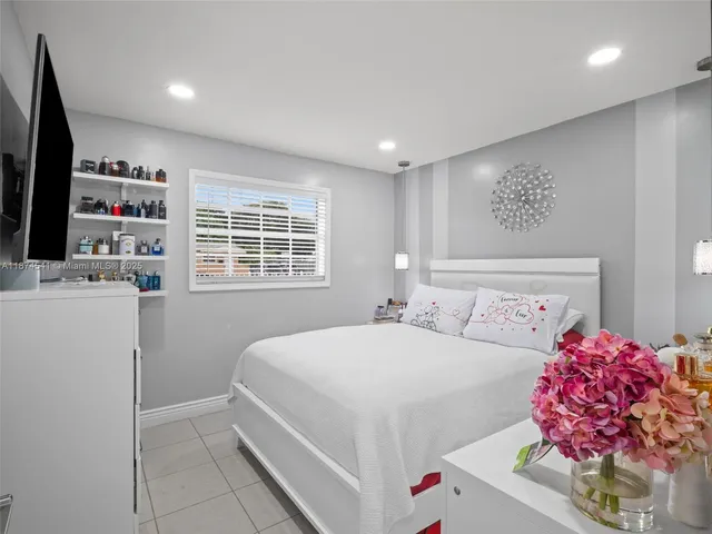 a bedroom with a bed dresser and a window