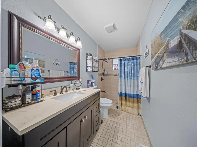 a bathroom with a sink vanity granite and toilet