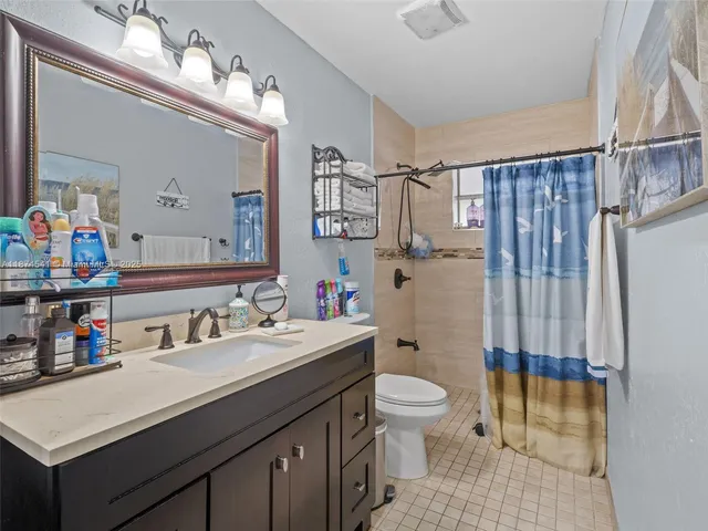 a bathroom with a sink toilet vanity and shower
