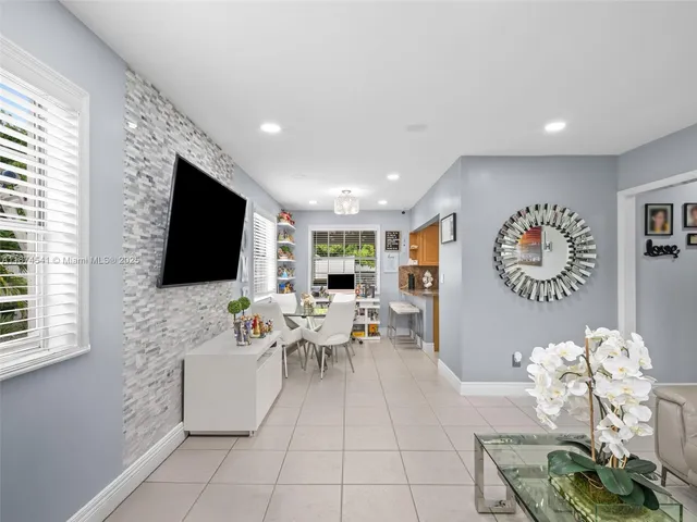a living room with furniture a flat screen tv and a large window