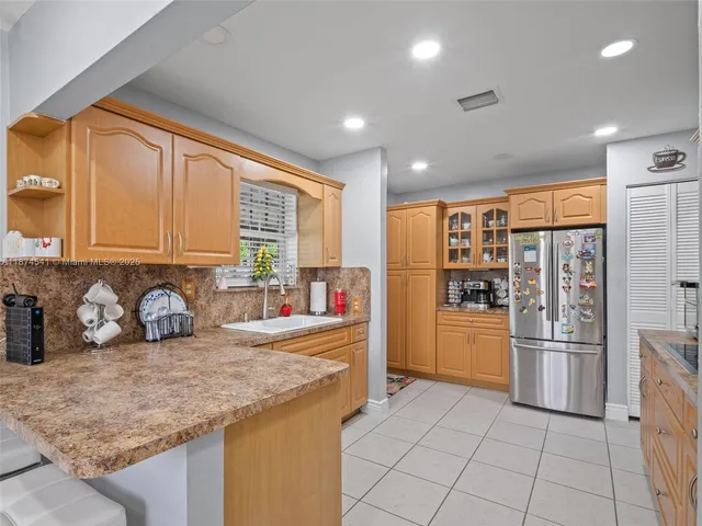 a kitchen with stainless steel appliances granite countertop a refrigerator and a sink