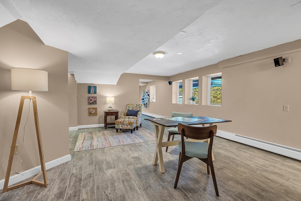16 Bulette Road Acton, MA 01720 - Photo 33 of 42 a living room with a table chairs and a wooden floor