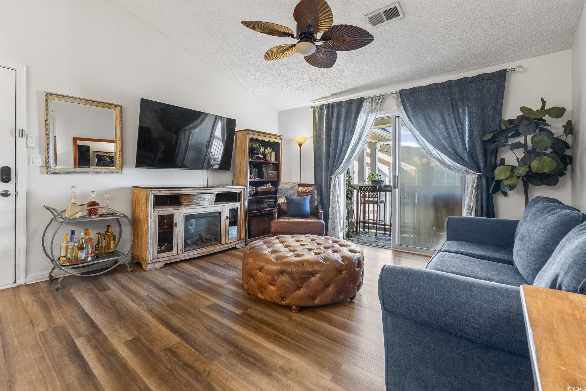 3753 Citation Way, Unit 438 Myrtle Beach, SC 29577 - Photo 12 of 33 Living room featuring vaulted ceiling, a ceiling fan, wood finished floors, and a textured ceiling