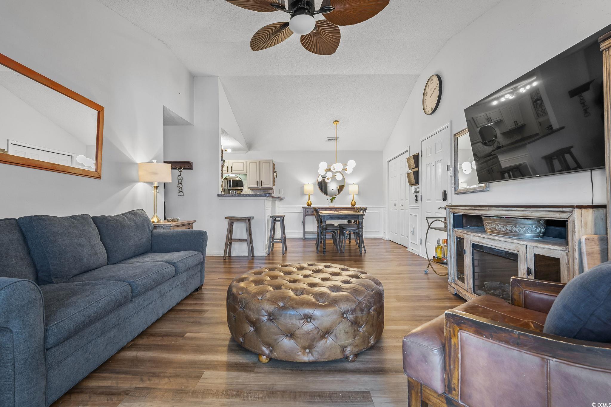 3753 Citation Way, Unit 438 Myrtle Beach, SC 29577 - Photo 14 of 33 Living area featuring a ceiling fan, wood finished floors, a chandelier, a textured ceiling, and high vaulted ceiling