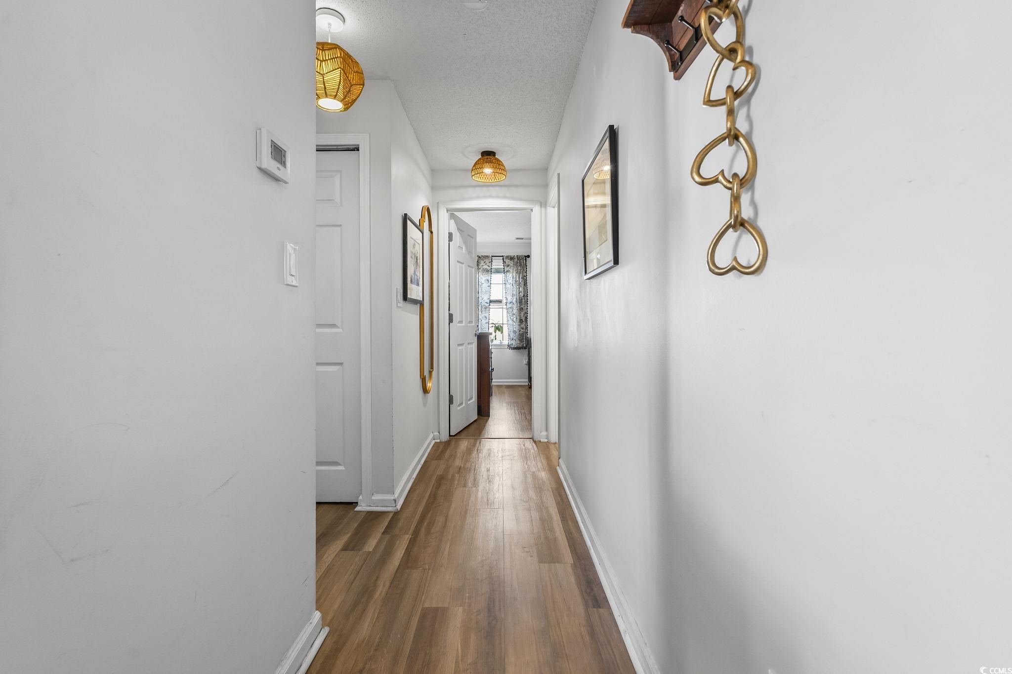 3753 Citation Way, Unit 438 Myrtle Beach, SC 29577 - Photo 15 of 33 Corridor featuring a textured ceiling and dark wood-style floors