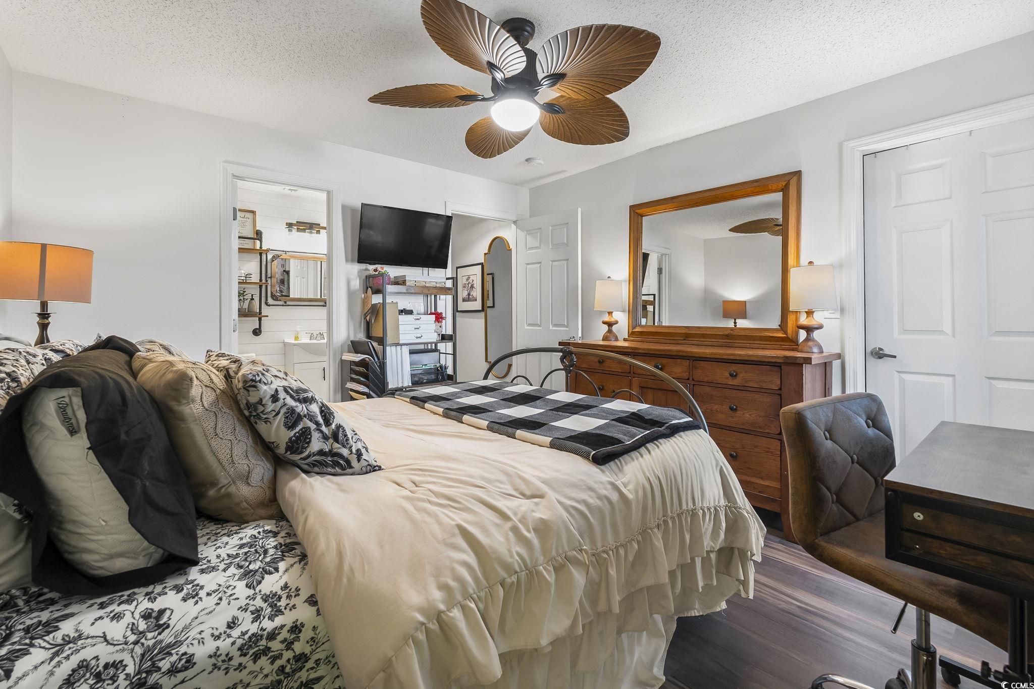3753 Citation Way, Unit 438 Myrtle Beach, SC 29577 - Photo 22 of 33 Bedroom with a textured ceiling, wood finished floors, connected bathroom, and ceiling fan