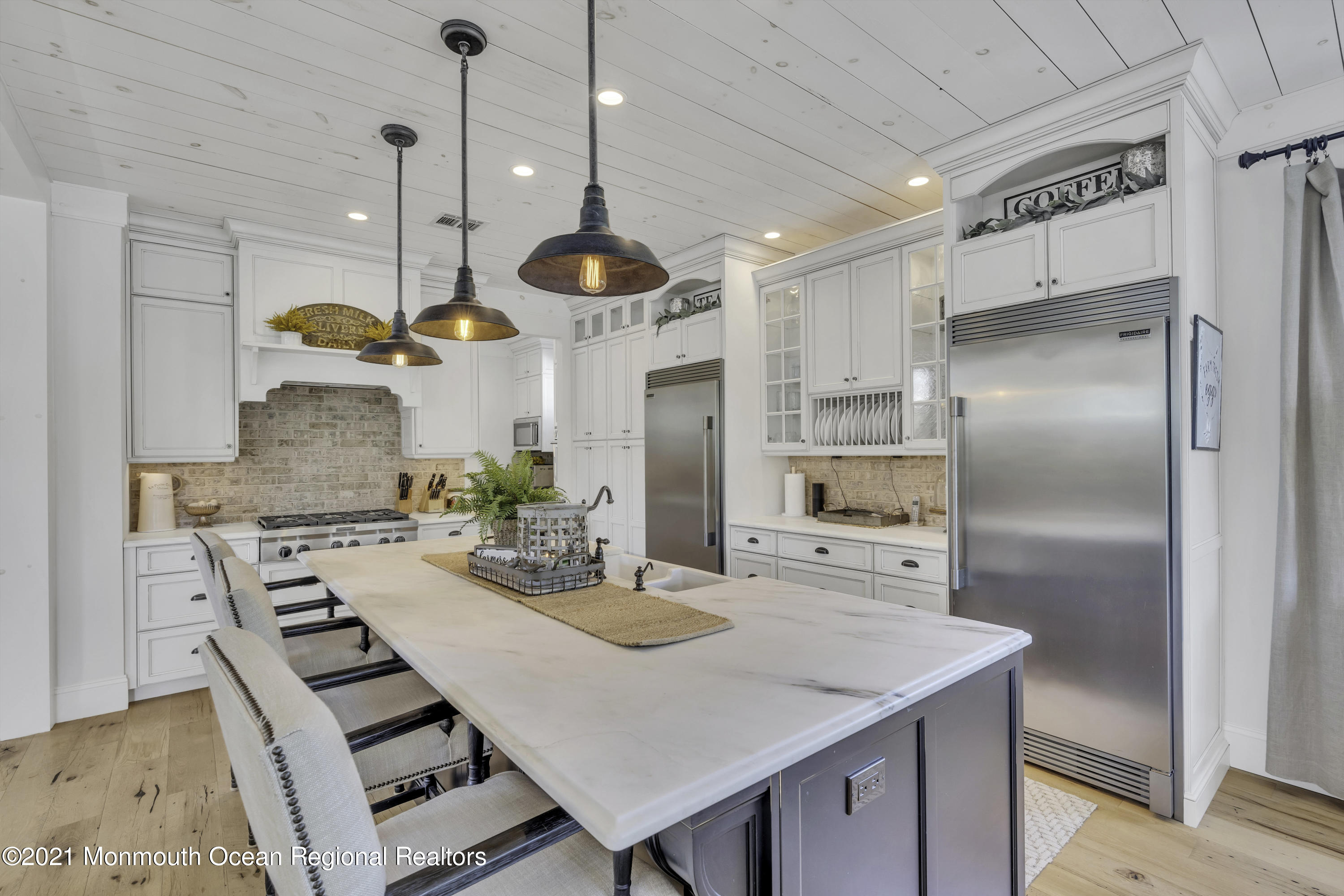 52 Marcellus Avenue Manasquan, NJ 08736 - Photo 24 of 79 a kitchen with stainless steel appliances kitchen island granite countertop a stove a refrigerator a oven a sink with a countertop and chairs