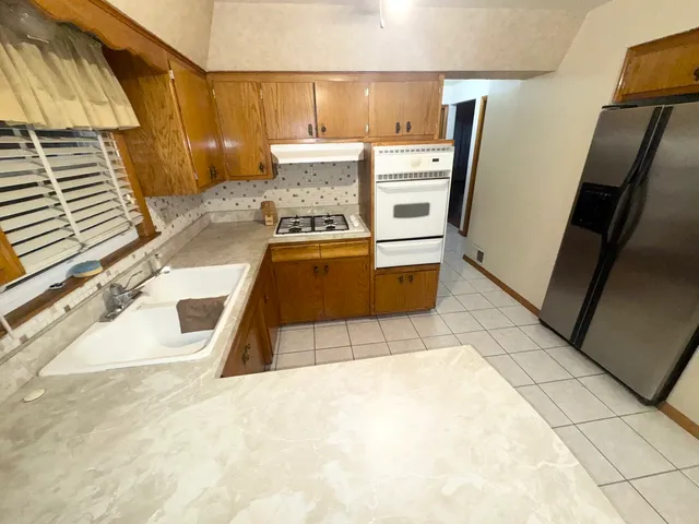 a kitchen with granite countertop a refrigerator and a stove
