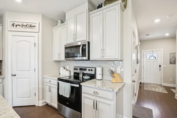a kitchen with stainless steel appliances granite countertop a refrigerator and a stove top oven