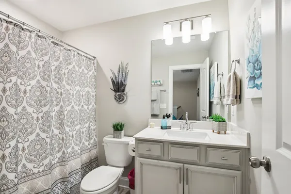 a bathroom with a sink vanity mirror and toilet