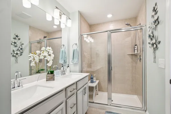 a bathroom with a shower sink vanity and mirror