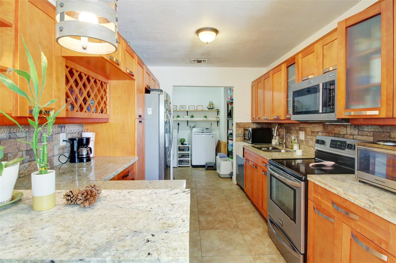 9755 Southwest 161st Street Miami, FL 33157 - Photo 11 of 32 a large kitchen with stainless steel appliances granite countertop a stove and cabinets