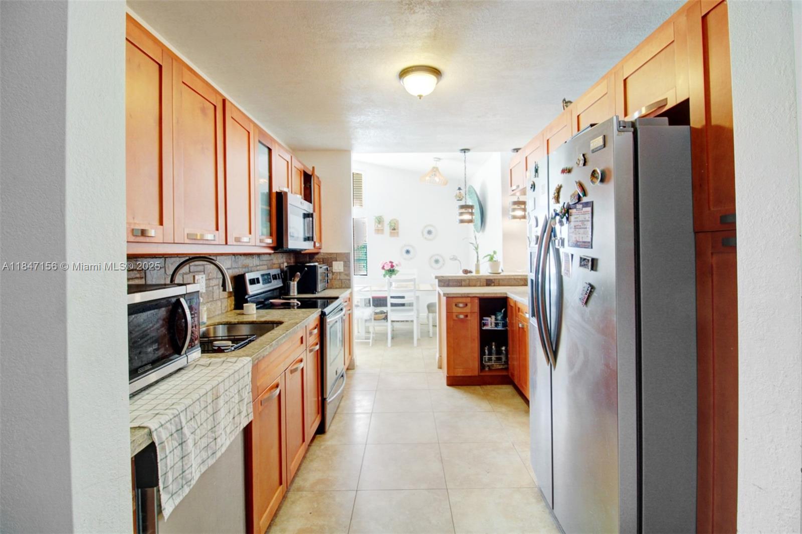 9755 Southwest 161st Street Miami, FL 33157 - Photo 12 of 32 a kitchen with stainless steel appliances granite countertop a refrigerator and a sink