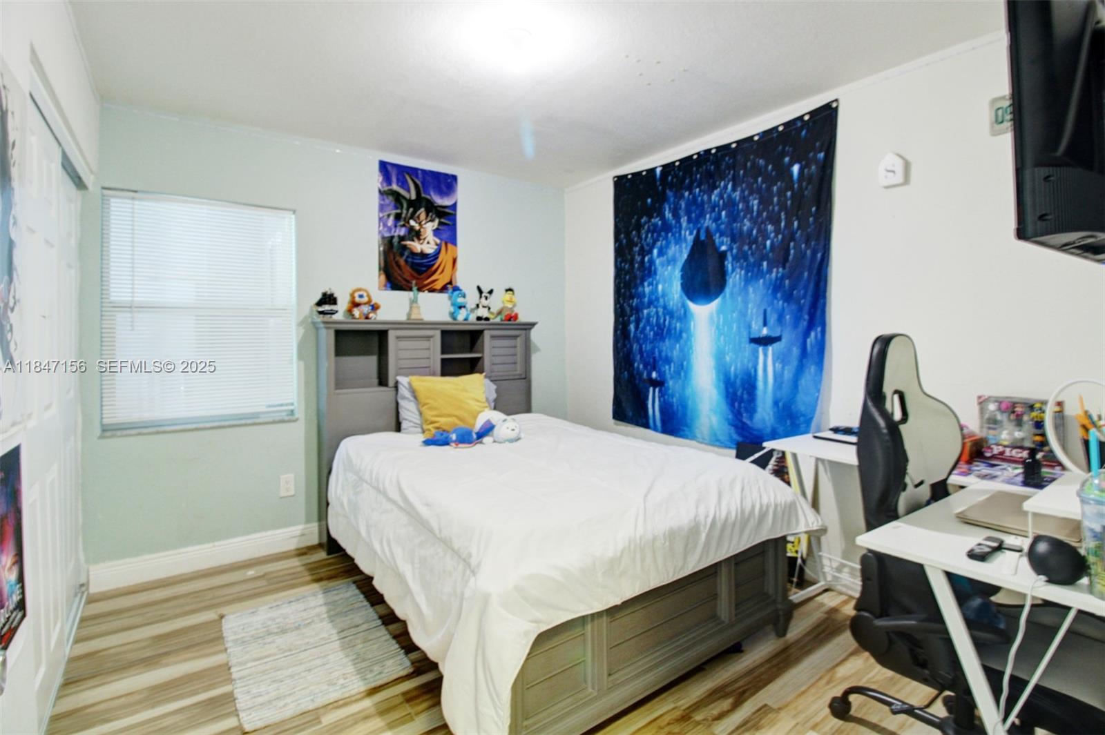 9755 Southwest 161st Street Miami, FL 33157 - Photo 14 of 32 a bed sitting in a bedroom next to a window