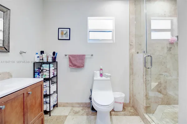 a bathroom with a sink toilet vanity and shower