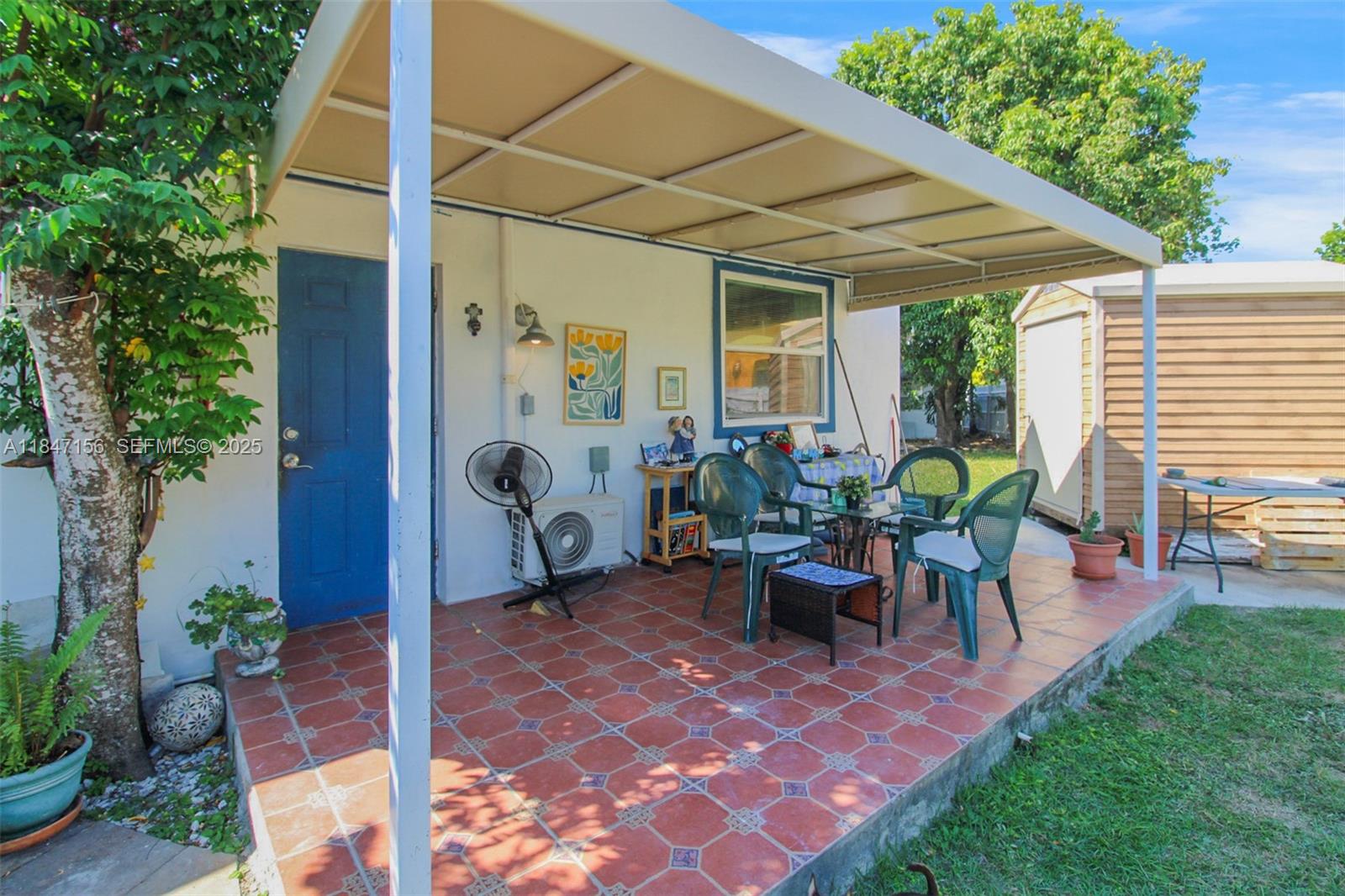 9755 Southwest 161st Street Miami, FL 33157 - Photo 22 of 32 a view of a patio with table and chairs potted plants and a palm tree
