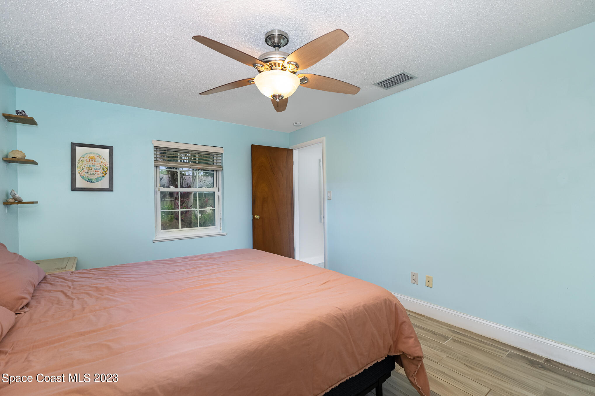 2842 Watkins Drive Melbourne, FL 32901 - Photo 15 of 39 a bedroom with a large bed window and a chandelier