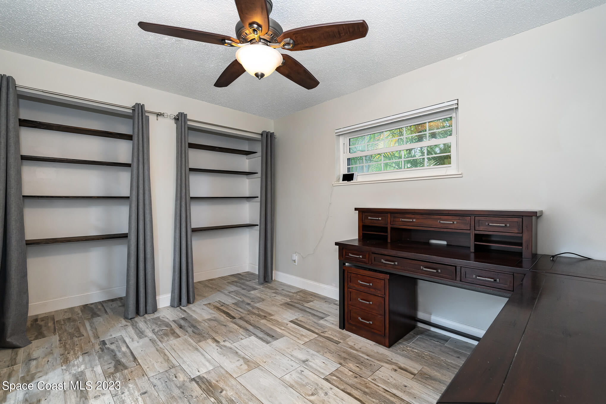 2842 Watkins Drive Melbourne, FL 32901 - Photo 18 of 39 a room with a desk and a ceiling fan
