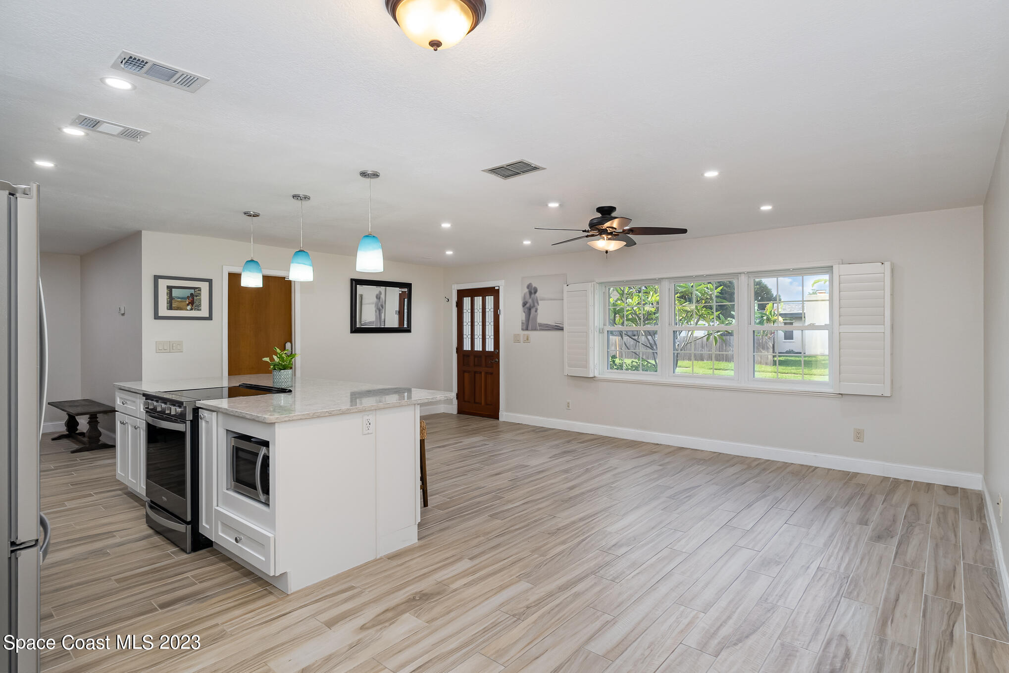 2842 Watkins Drive Melbourne, FL 32901 - Photo 3 of 39 an open kitchen with kitchen island and stainless steel appliances