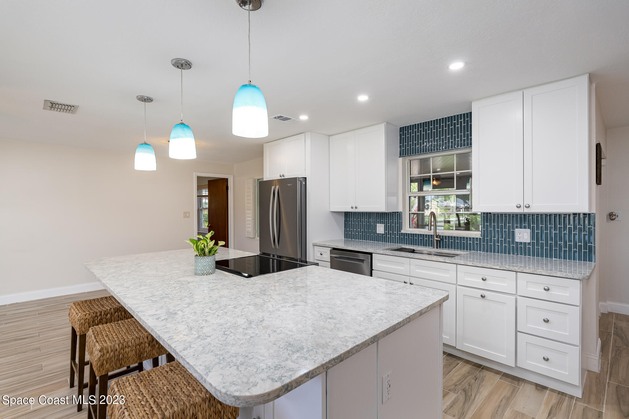2842 Watkins Drive Melbourne, FL 32901 - Photo 6 of 39 a kitchen with granite countertop a sink a center island a counter space and cabinets