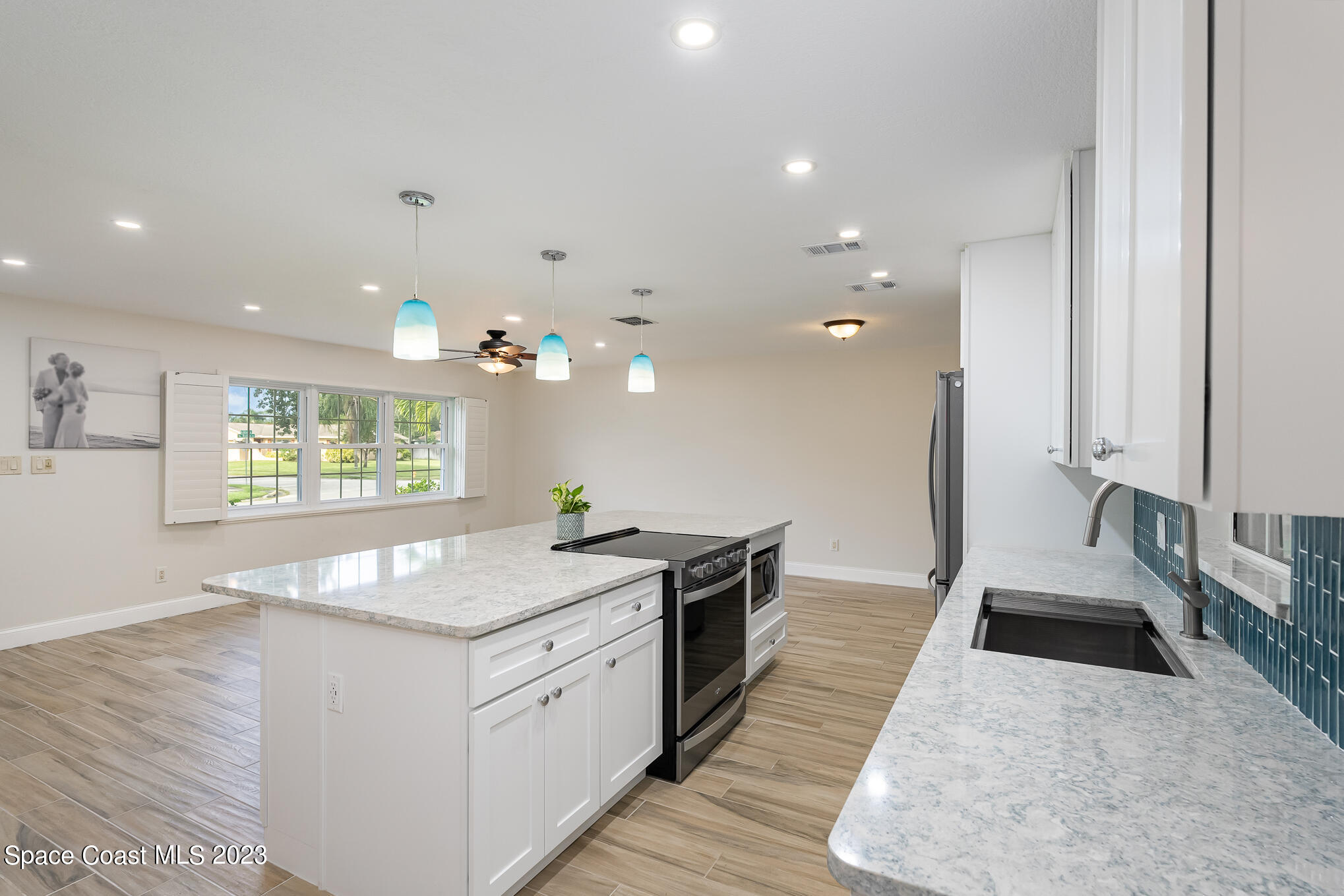 2842 Watkins Drive Melbourne, FL 32901 - Photo 7 of 39 a kitchen with granite countertop a stove a sink and a refrigerator