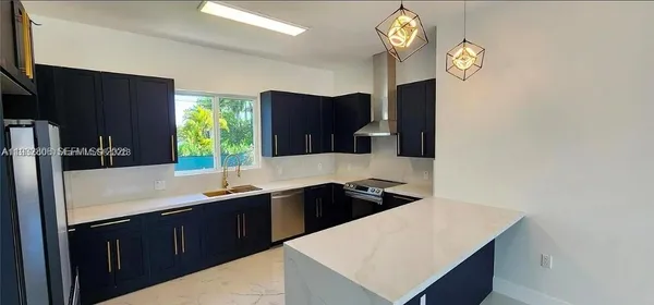 a kitchen with a sink dishwasher a stove a refrigerator and a sink