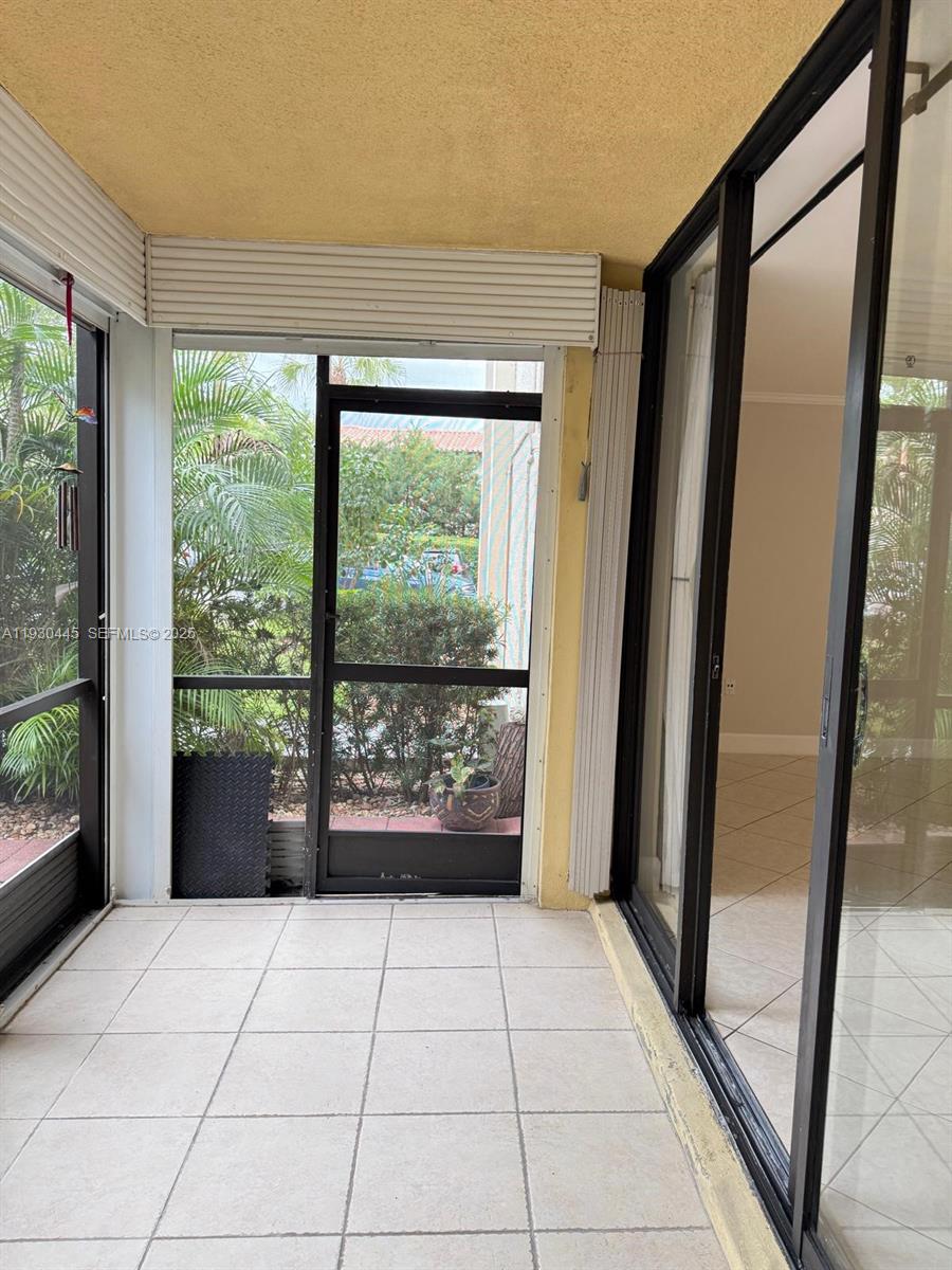 671 Northeast 195th Street, Unit 121E Miami, FL 33179 - Photo 15 of 39 a view of an entryway with wooden floor and garden view