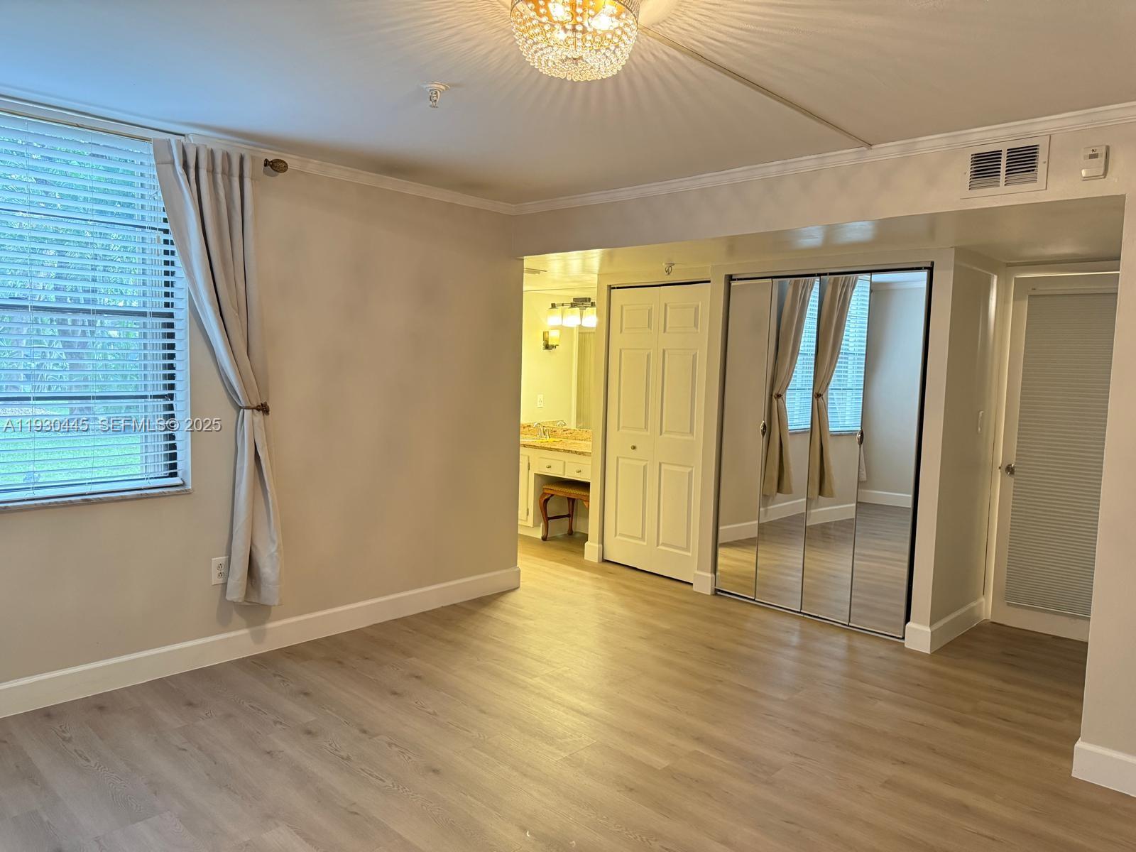 671 Northeast 195th Street, Unit 121E Miami, FL 33179 - Photo 23 of 39 a view of an empty room with wooden floor and a window