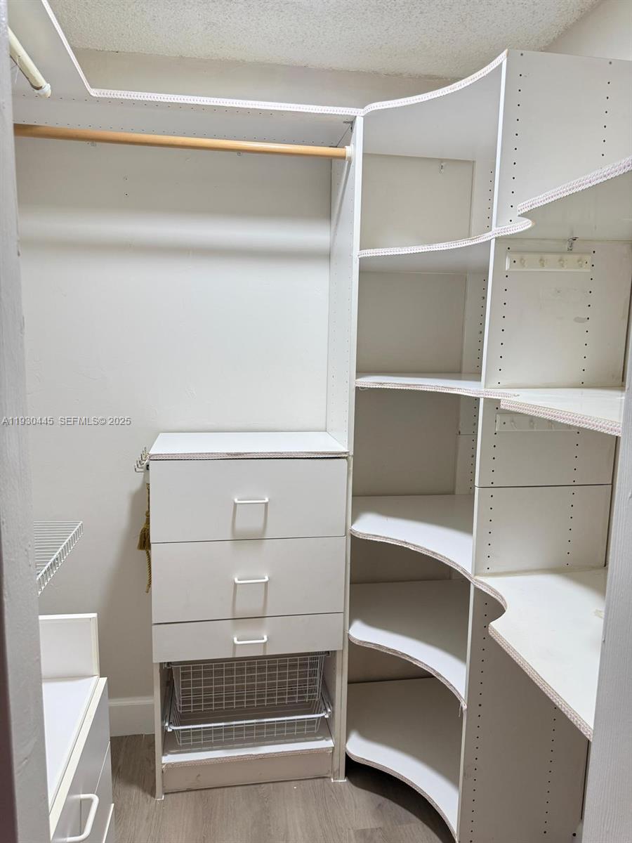671 Northeast 195th Street, Unit 121E Miami, FL 33179 - Photo 24 of 39 a view of walk in closet with empty racks