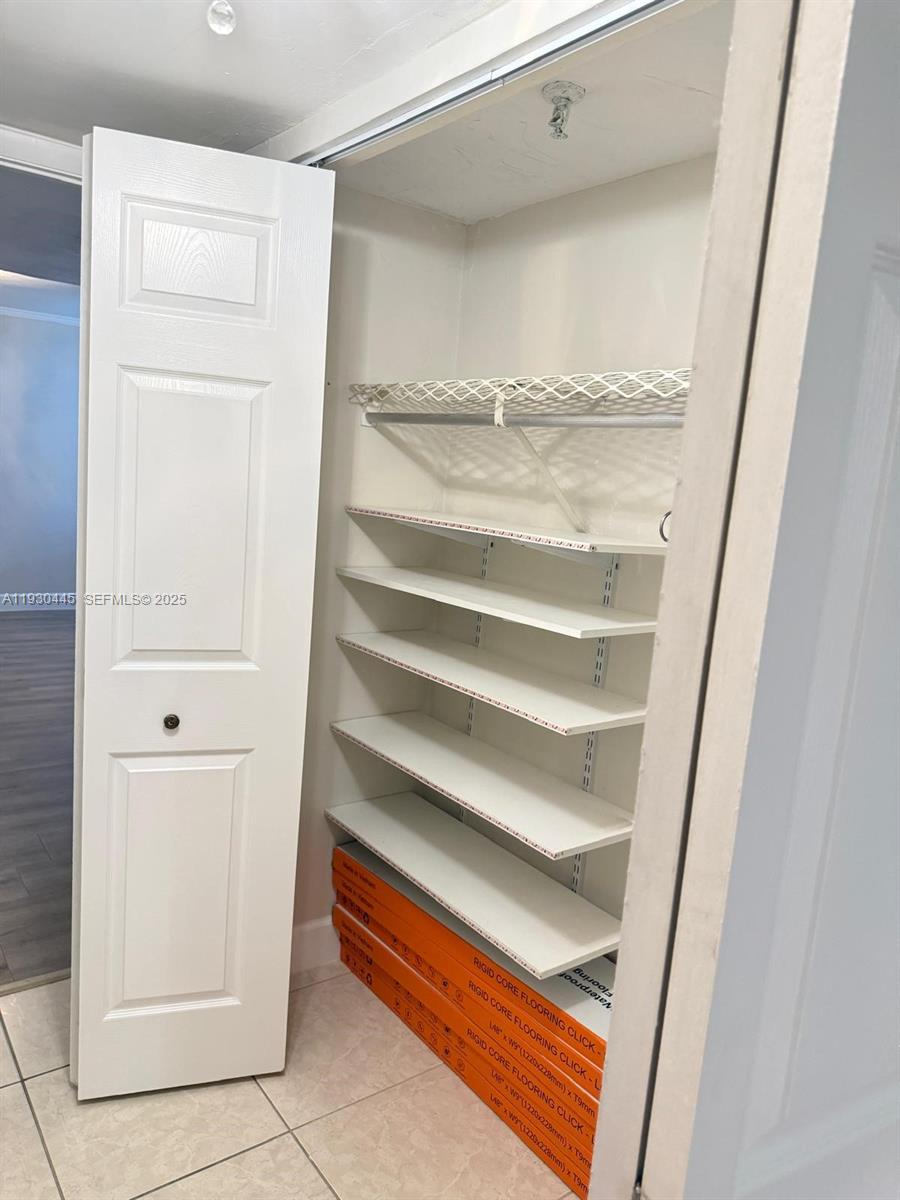 671 Northeast 195th Street, Unit 121E Miami, FL 33179 - Photo 26 of 39 a view of walk in closet with empty racks