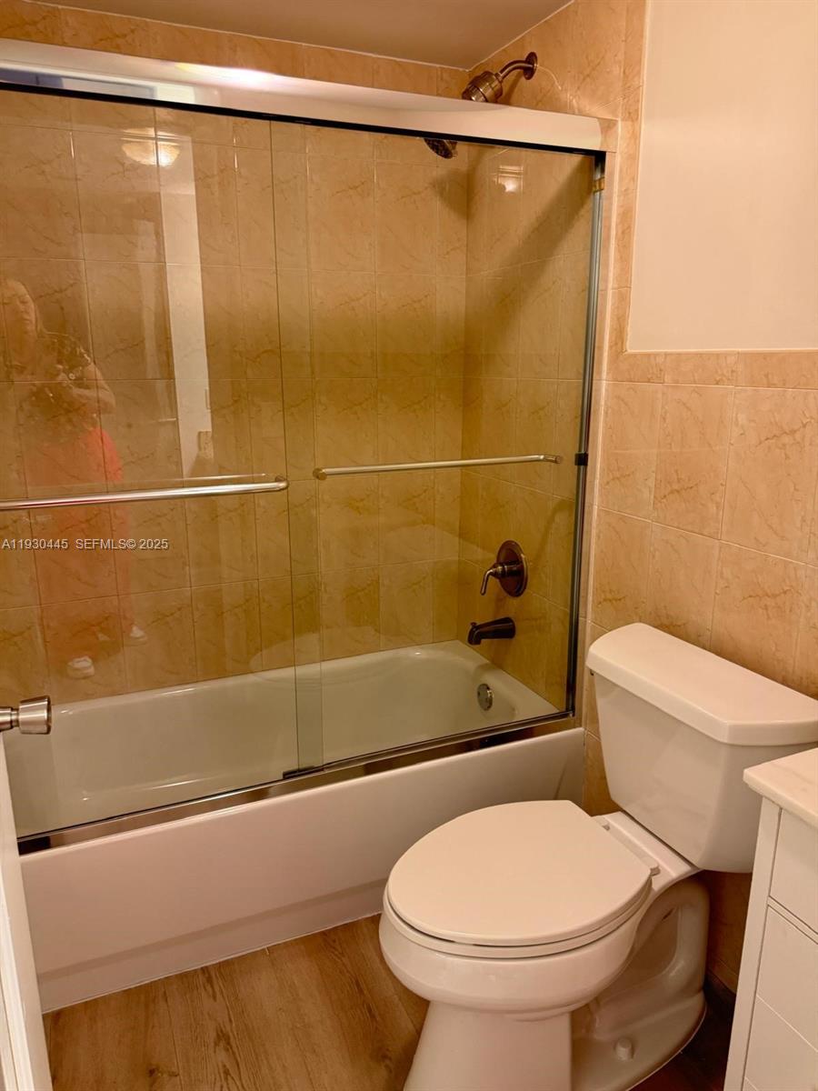 671 Northeast 195th Street, Unit 121E Miami, FL 33179 - Photo 27 of 39 a white toilet sitting next to a bath tub and a shower