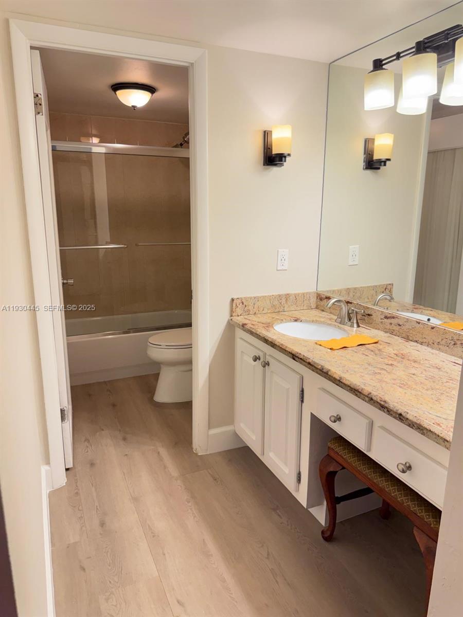 671 Northeast 195th Street, Unit 121E Miami, FL 33179 - Photo 28 of 39 a bathroom with a granite countertop sink toilet and shower