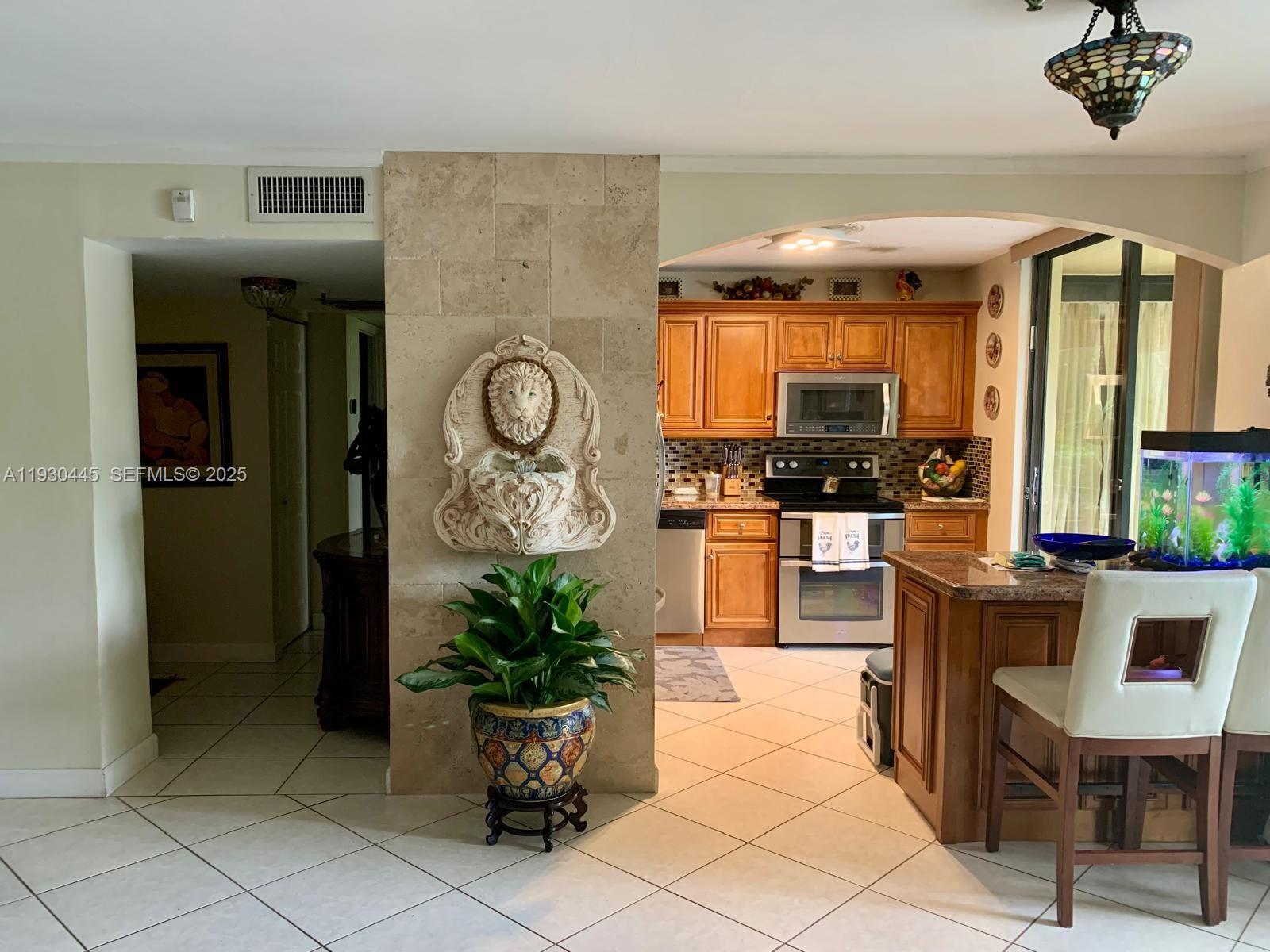 671 Northeast 195th Street, Unit 121E Miami, FL 33179 - Photo 36 of 39 a lobby with furniture and flat screen tv