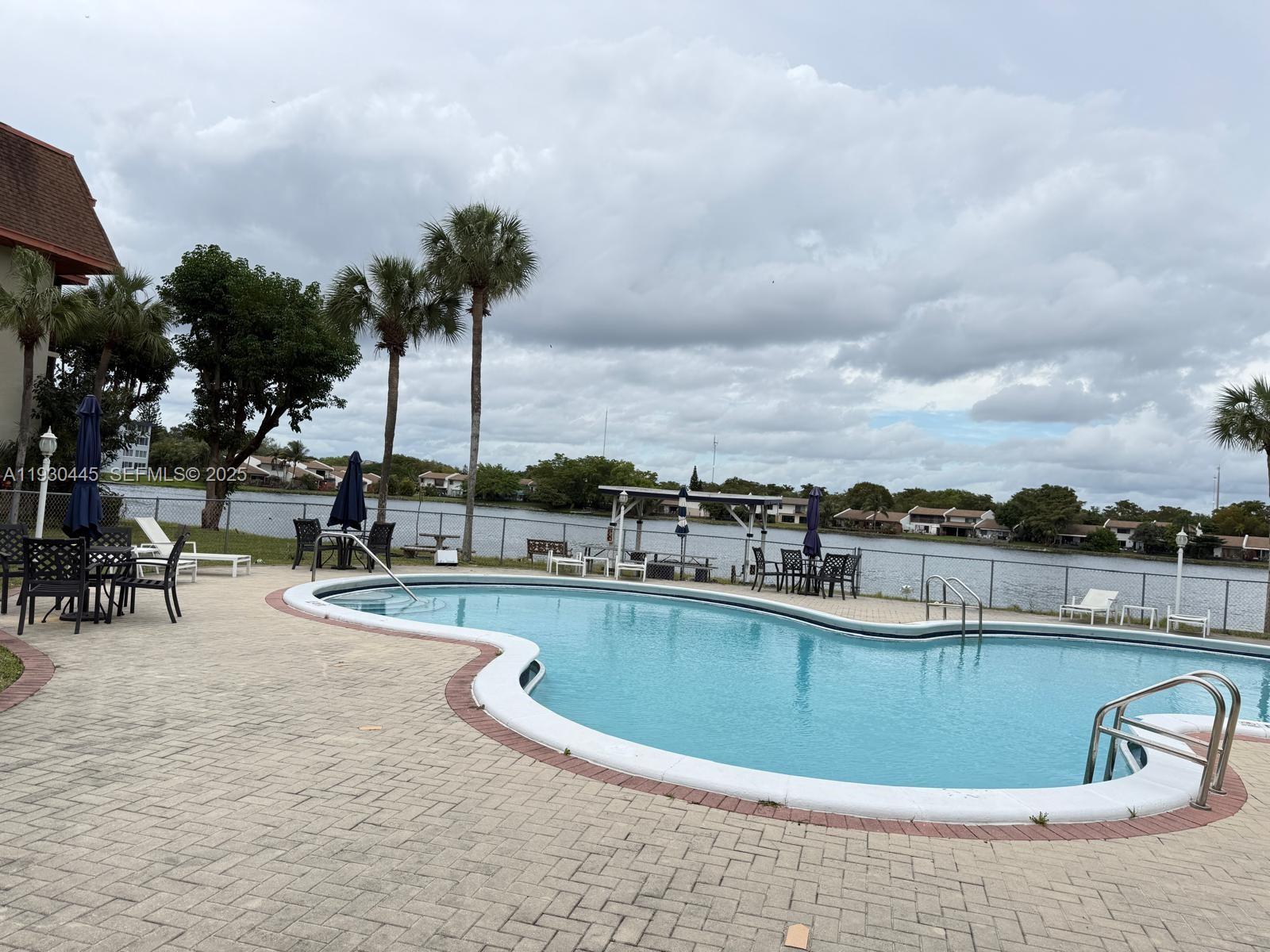 671 Northeast 195th Street, Unit 121E Miami, FL 33179 - Photo 10 of 39 a view of a swimming pool with outdoor seating