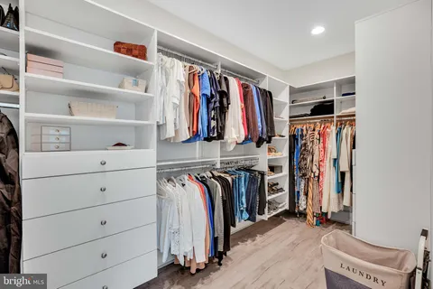 a view of walk in closet with clothes and shoes