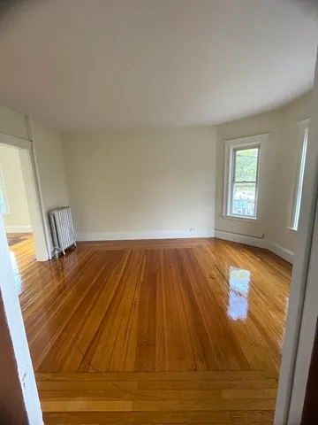 a view of a room with wooden floor and window