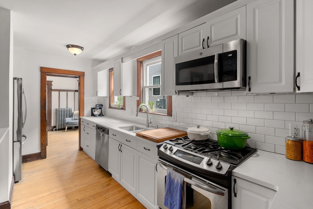 18 Park Road, Unit 1 Belmont, MA 02478 - Photo 18 of 36 a kitchen with stainless steel appliances a stove a microwave and sink